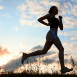 A silhouette of a young woman jogging in the countryside to illustrate physical activity